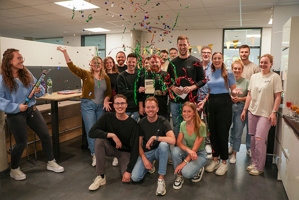 The garage33 team celebrates the investment in the start-up "Steets" together with the three founders by setting off a confetti cannon.