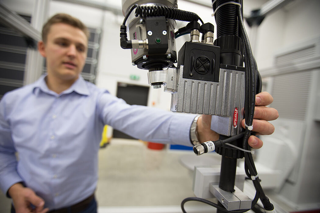 Stefan Schütz (Fraunhofer IEM) zeigt die Zusammenarbeit mit einem kollaborativen Roboter. Foto: David Gense
