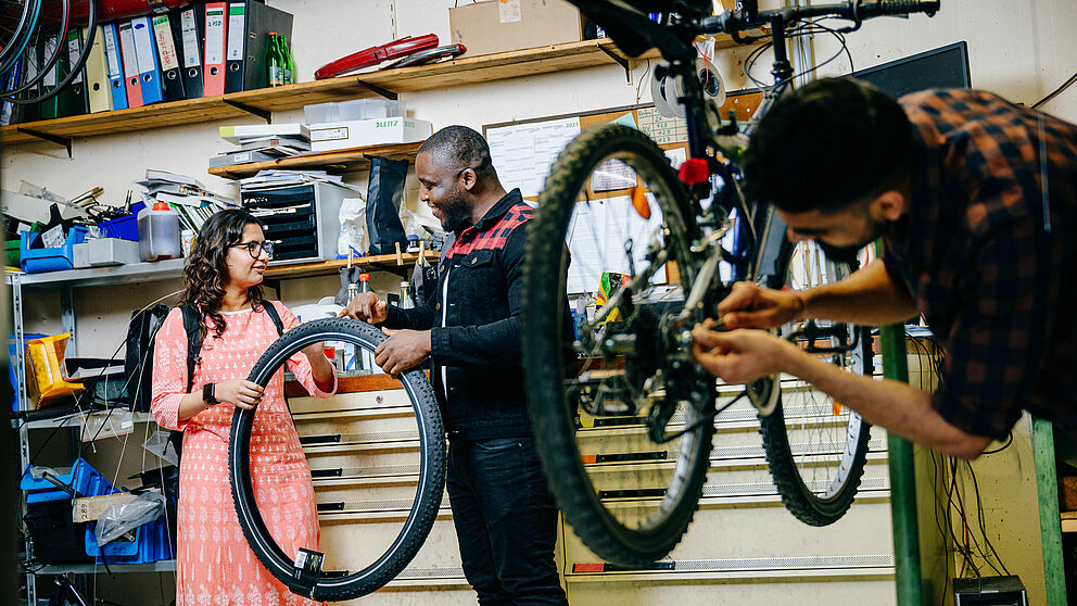 Studierende reparieren Fahrräder.