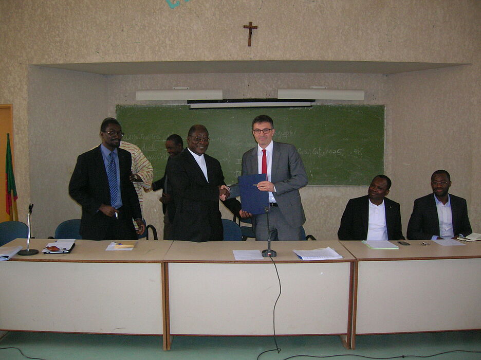 Foto (UCAC): Nach der Unterzeichnung des Vertrags durch den Rektor der Katholischen Universität Zentralafrikas. Von links im Vordergrund: Dekan der Fakultät für Sozialwissenschaften und Betriebswirtschaftslehre Pater Dr. Abel Beranger N’Djomon, Rekto
