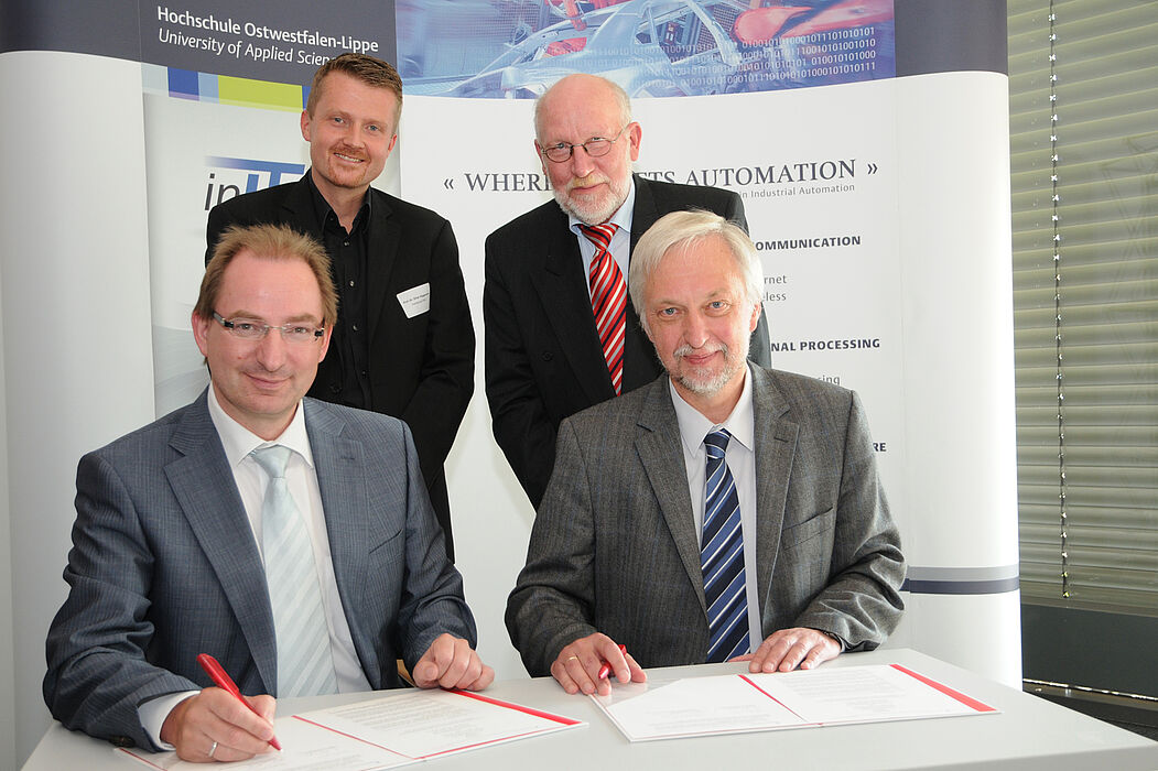 Dr. Oliver Herrmann (Präsident der Hochschule OWL, links) und Professor Dr. Wilhelm Schäfer (Vizepräsident für Forschung und Wissenschaftlichen Nachwuchs an der Universität Paderborn, rechts), unterzeichnen den Kooperationsvertrag, der erstmals eine 
