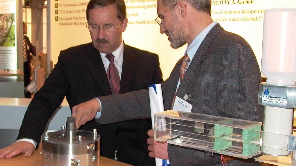 Foto: Minister Schartau (li.) lässt sich von Dr.-Ing. Karl-Peter Jäker, Universität Paderborn, das Prinzip der Flügelzellenpumpe erklären