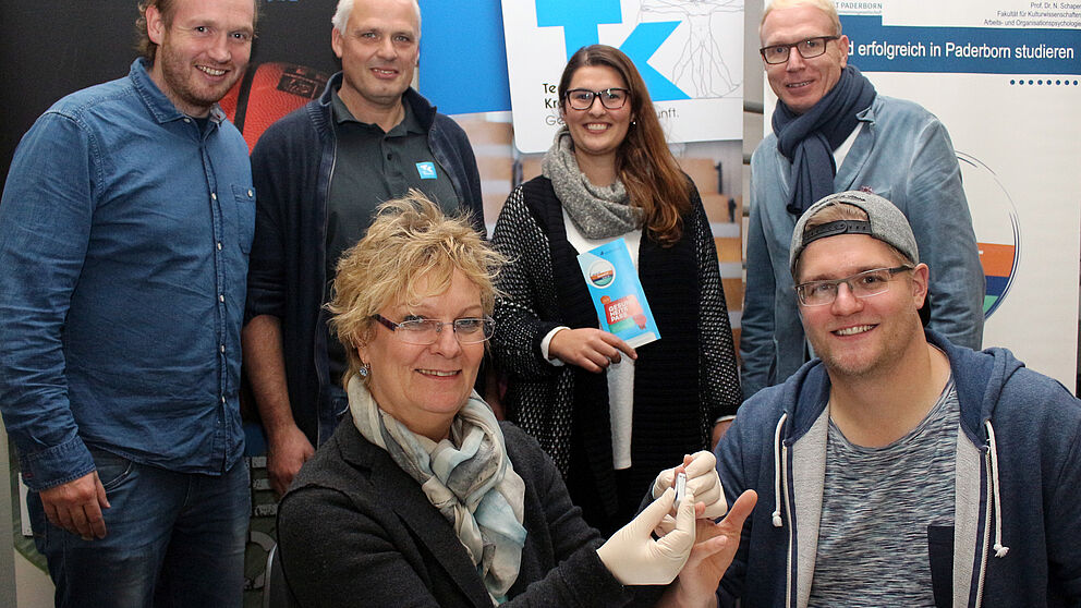 Foto (Universität Paderborn, Heiko Appelbaum): Das tat nicht weh: Arne Östlund (vorne rechts) ließ sich von Christa Richter (vorne links) screenen. An der Aktion waren beteiligt (hinten v. l.): Dennis Fergland (mein beneFIT@upb.de), Hans-Norbert Blome 