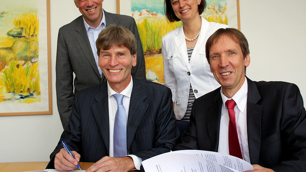 Foto (Universität Paderborn, Patrick Kleibold): Prof. Dr. Nikolaus Risch (vorn links) und Rüdiger Matisz, die den Kooperationsvertrag unterzeichnen; Raymund Koch und Dr. Yvonne Salman freuen sich mit ihnen.