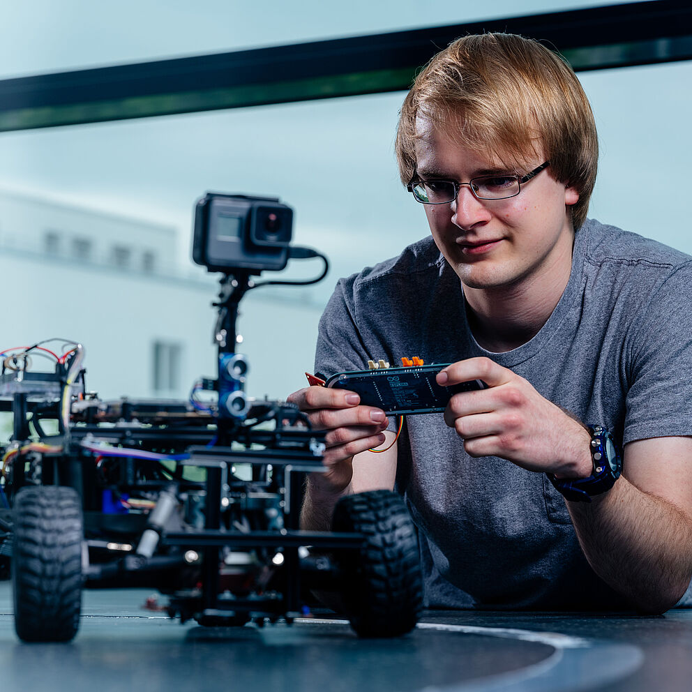 Studierender steuert einen Roboter