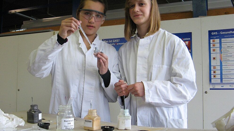 Foto (Universität Paderborn, Simone Rudolph): Zwei Schülerinnen experimentieren bei einem Lackchemie-Workshop.