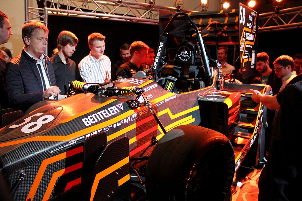 Foto (Universität Paderborn, Ricarda Michels): Interessiert begutachten Besucher den neuen Rennboliden.