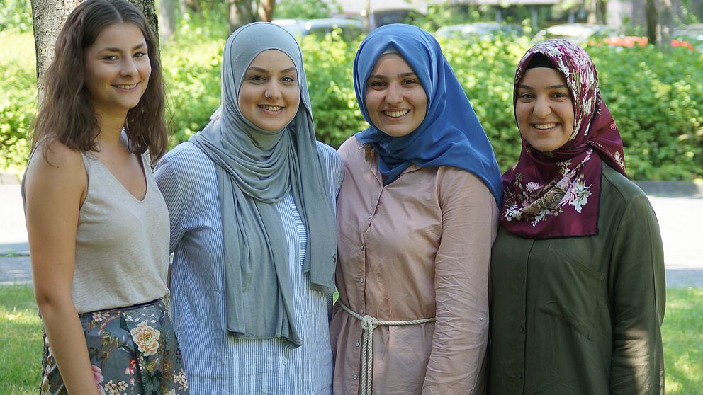 Foto (PLAZ, Björn Heerdegen): Die aktiven Mentorinnen Jana (1. v. l.) und Aysegül (4. v. l.) und ihre zukünftigen Nachfolgerinnen Derya und Sevval (Mitte) ziehen eine positive Bilanz und freuen sich auf kommende Erfahrungen.