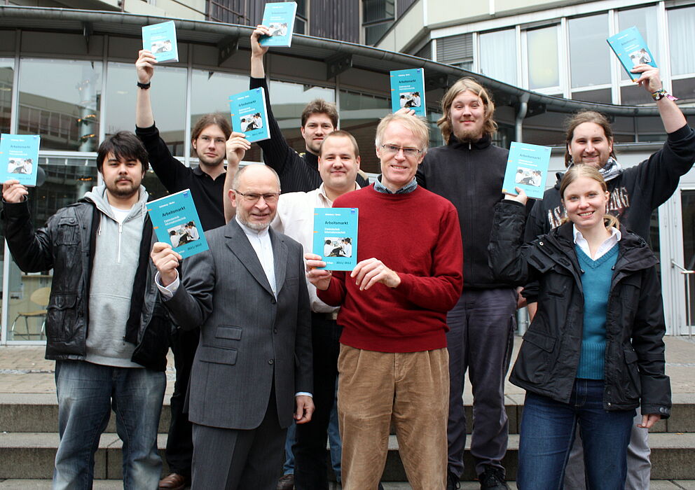 Foto (Universität Paderborn, Patrick Kleibold): Herausgeber Dr. Ingo-G. Wenke (links) hat Prof. Dr. Reinhold Häb-Umbach, Institutsleiter Elektrotechnik und Informationstechnik der Universität Paderborn, das neue VDE-Jahrbuch überreicht. Erste Reihe vo