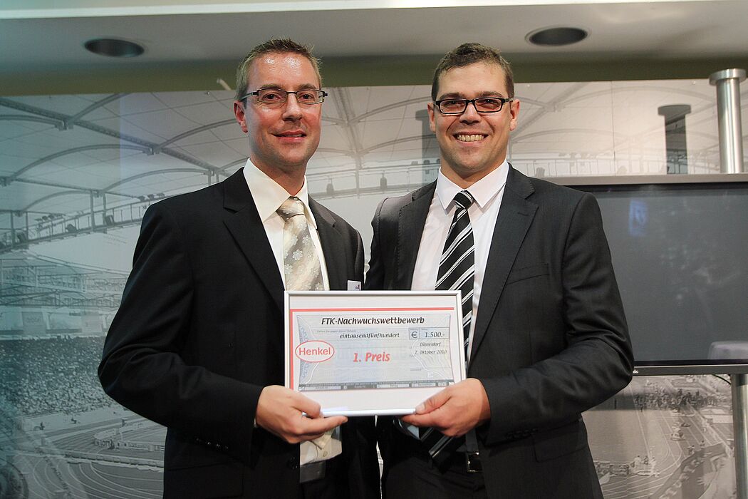 Foto (Universität Paderborn): Herr Kohlstrung (Henkel AG & Co. KGaA) überreicht den ersten Preis an Sven Bednorz (LWF, Uni Paderborn) für dessen herausragende Forschungsarbeit.