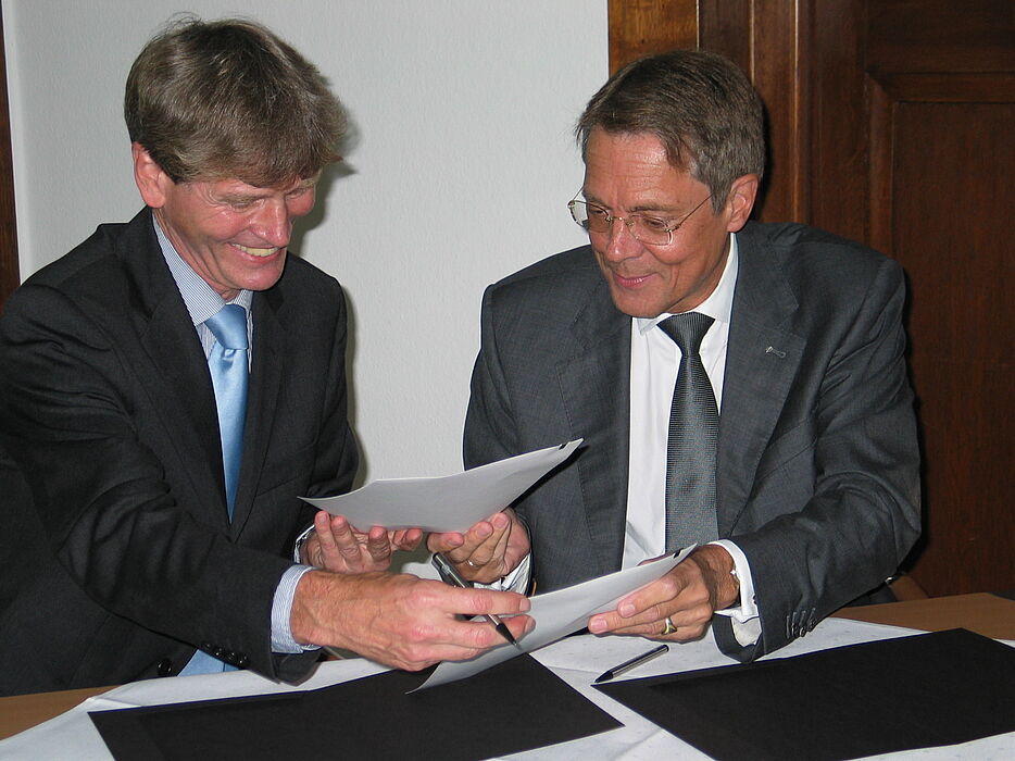 Foto (Ramona Wiesner): Die von Hella gestiftete Juniorprofessur für die Universität Paderborn wird vertraglich besiegelt durch Professor Dr. Nikolaus Risch (links) und Dr. Jürgen Behrend.