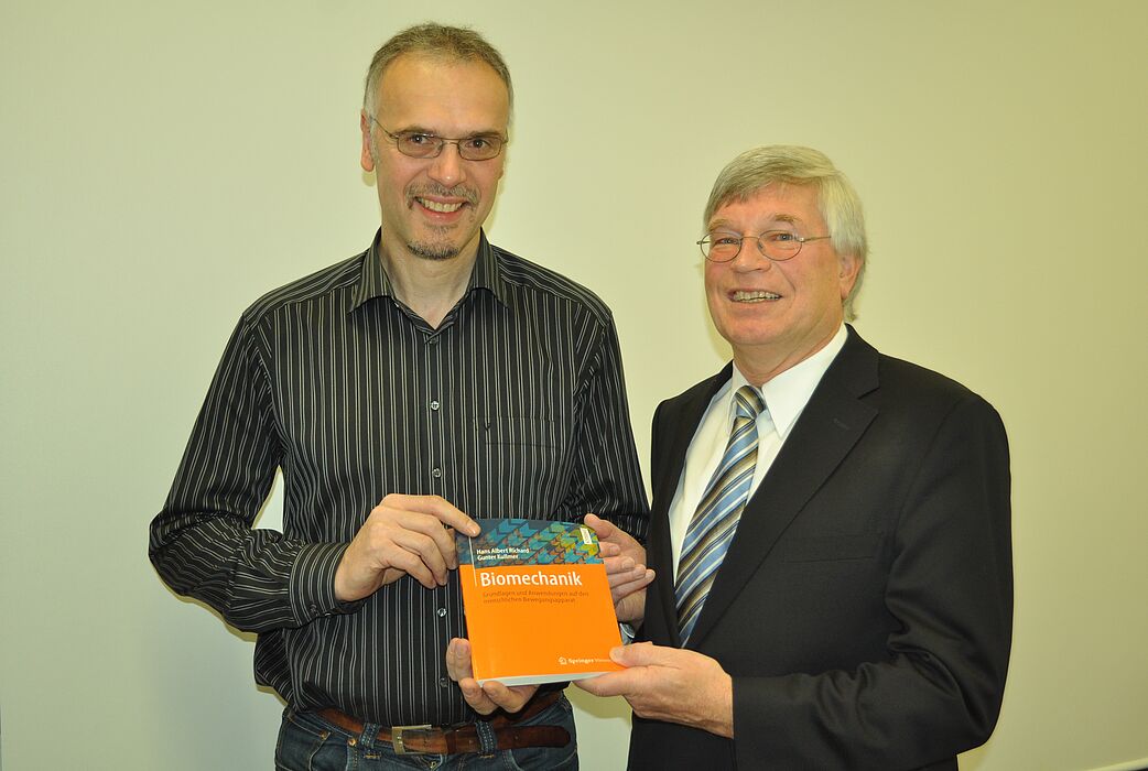 Foto (Universität Paderborn): Prof. Dr.-Ing. Gunter Kullmer (li.) und Prof. Dr.-Ing. Hans Albert Richard mit dem neuen Fachbuch „Biomechanik“.