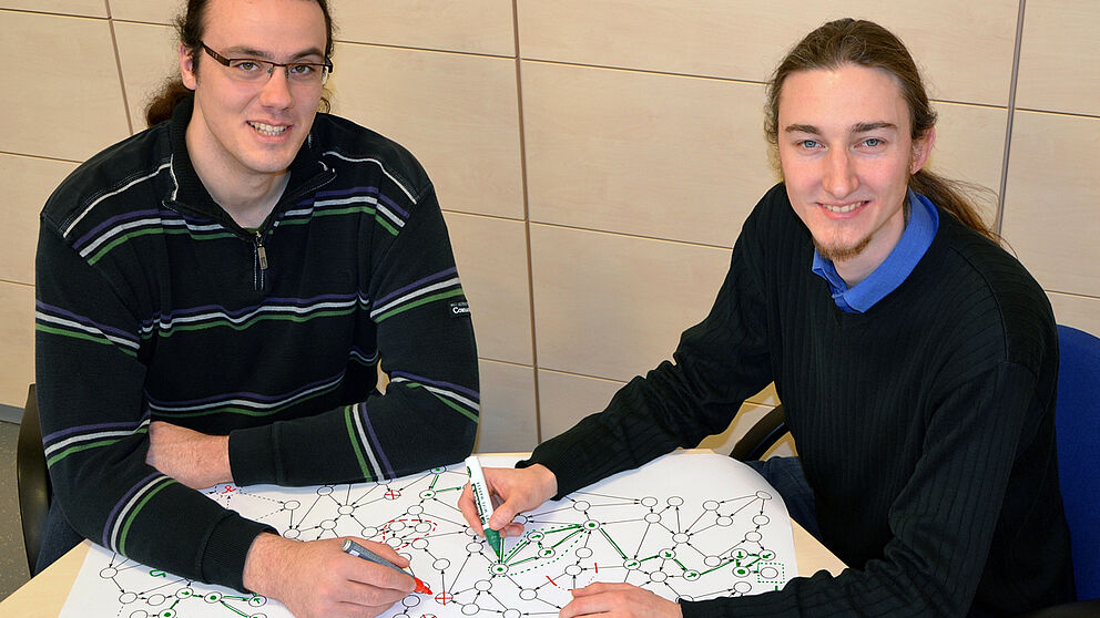 Foto (Universität Paderborn, Jana Neuhaus): Graphabstraktion anschaulich: Dominik Steenken und Steffen Ziegert (rechts) bei Planung und Fehlervermeidung.