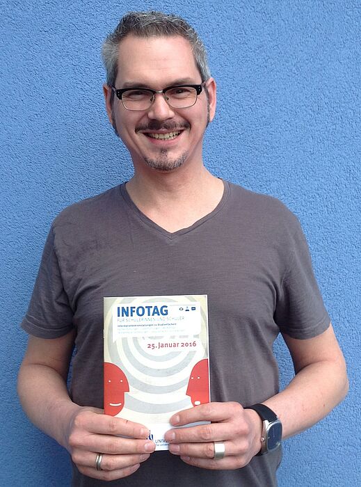 Foto (Universität Paderborn, Sammy Al-Hamwi): Jörn Sickelmann, stellv. Leiter der Zentralen Studienberatung, mit dem aktuellen Programmheft.