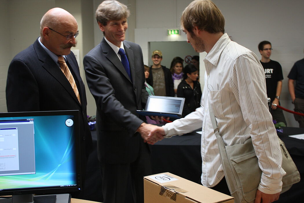 Foto (Frauke Döll): Präsident Prof. Dr. Nikolaus Risch und Kanzler Jürgen Plato überreichen die ersten Netbooks an die neuen Studierenden.
