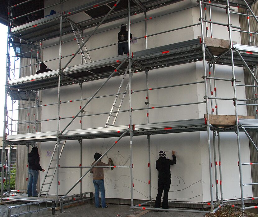 Foto (Universität Paderborn, Martin Decking): Noch ganz ohne Farben präsentierte sich die Wand des Gebäudes E bei Vorbereitungsarbeiten am 12.11.2010.