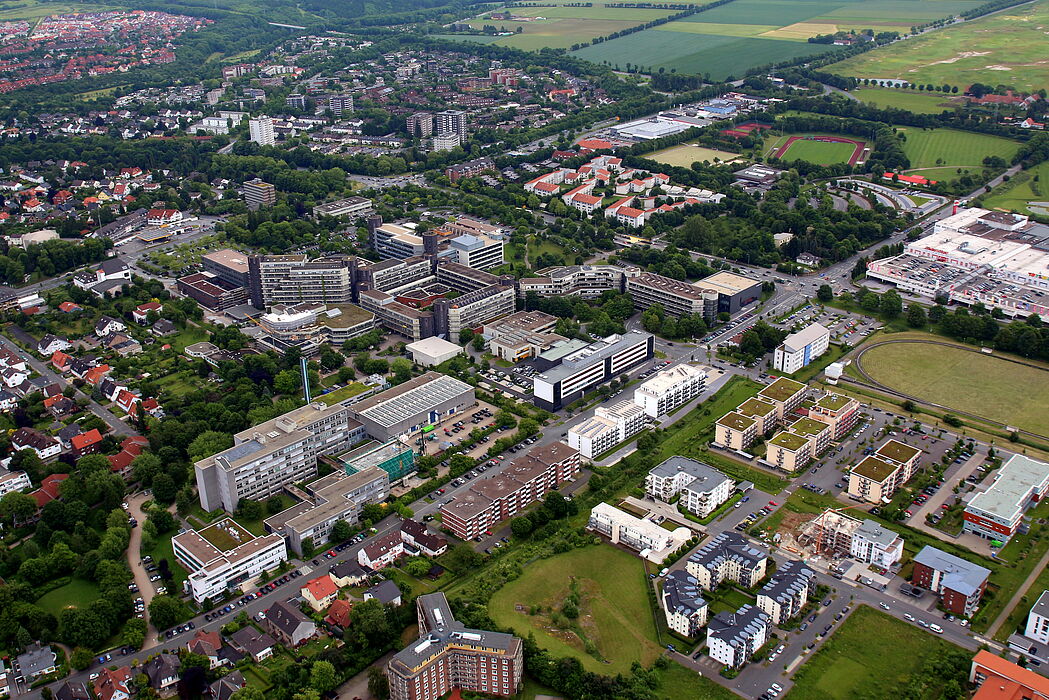 Foto (Universität Paderborn, Patrick Kleibold): Luftbild der Uni vom 14. Juni 2013. Im Hintergrund der neue Golfplatz Haxterpark.