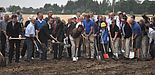 Foto (Mark Heinemann): Großer Spatenstich: Beim Beginn der ersten Baumaßnahme wollten alle mit dabei sein. Helmut Böhmer, hier im braunen Shirt rechts neben Paderborns Bürgermeister Heinz Paus, freute sich, dass es nun endlich losgeht.