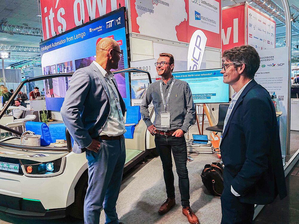Scientists from Paderborn University stand at the it's OWL joint stand  at the hannover messe and exchange ideas.