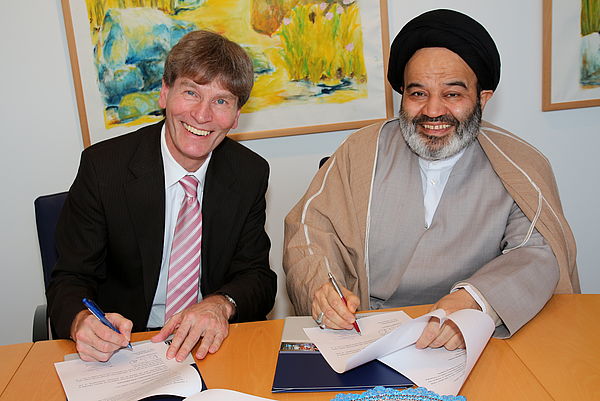 Foto (Universität Paderborn, Patrick Kleibold): Prof. Dr. Nikolaus Risch und Seyed Abdolhassan Navab unterzeichnen die Kooperationsvereinbarung zwischen den beiden Universitäten.