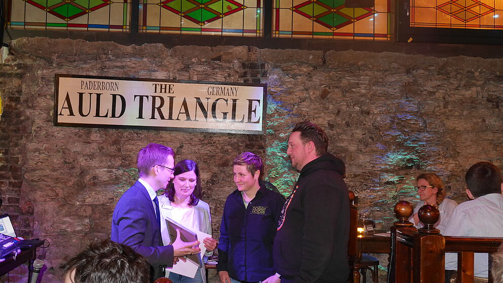 Foto [TecUP, Kristina Reineke]: (v. l. n. r.) Christian Horlitz von den Wirtschaftsjunioren Paderborn-Höxter und Dr. Claudia Auinger (IHK Paderborn) gratulieren dem Gewinnerteam Doggylicious Food-Truck (Sandra Flore und Sven Vieth).