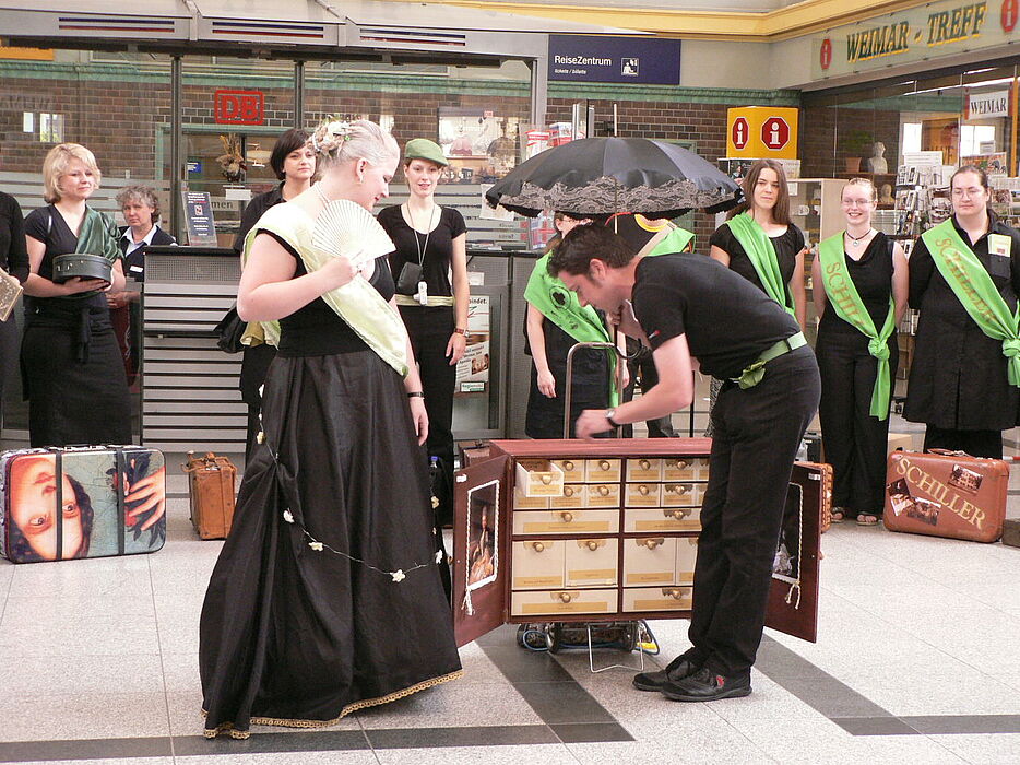 Foto: Bahnhof Weimar, Performance von Sonja Böhlen als Herzogin Anna Amalia und Mirko Winter als Kavalier zu einem Museumskoffer
