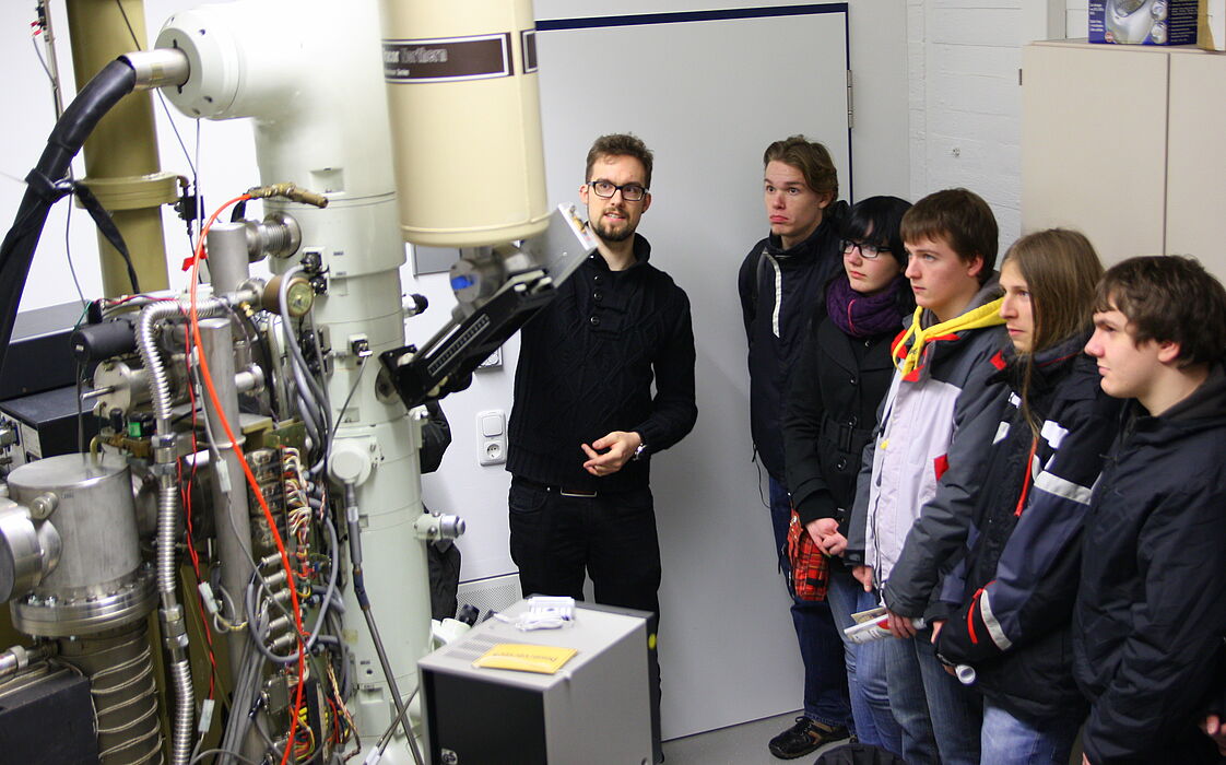 Foto (Universität Paderborn, Patrick Kleibold): Johannes Pauly zeigt Schülern des Franz-Stock Gymnasiums aus Neheim die Labore der Physik.