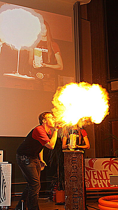 Foto: Physikstudent Fabian Meyer zeigt mit einem Löffel Mehl die Wirkung einer Mehlstaub-Explosion.