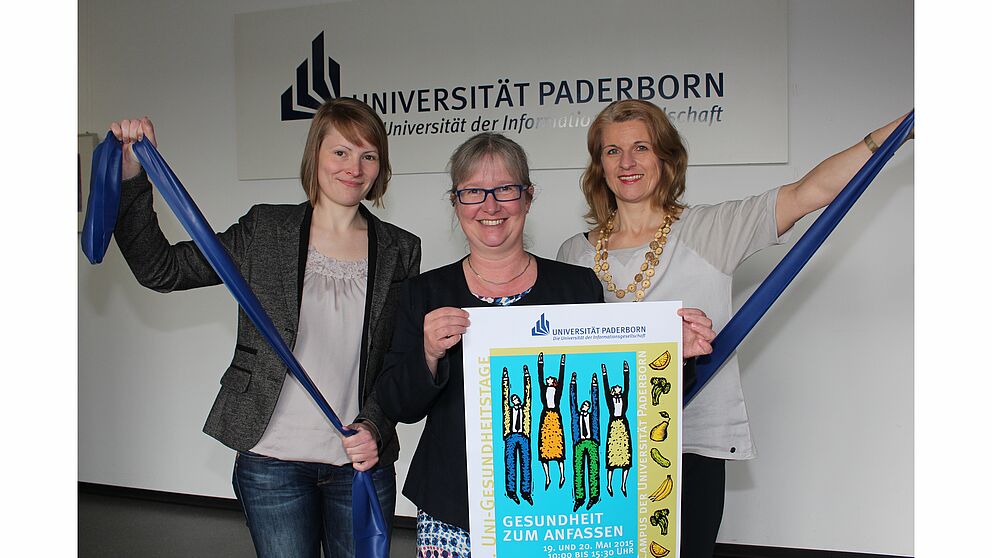 Foto (Universität Paderborn, Frauke Döll): Melissa Naase, Simone Probst und Diana Riedel (v. l.) laden zu den Uni-Gesundheitstagen 2015 ein.