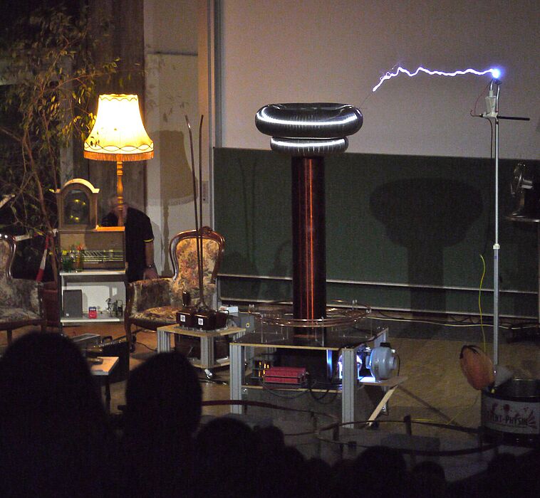 Foto: Der in Wohnzimmer-Deko platzierte Tesla-Transformator erzeugt einen gewaltigen Blitz.