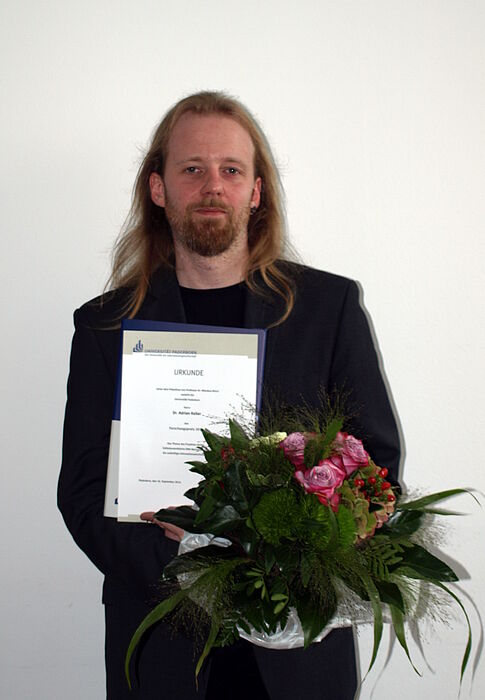 Foto (Universität Paderborn, Bianca Oldekamp): Dr. Adrian Keller nahm den Forschungspreis 2014 für das Projekt „Selbstassemblierte DNA-Nanodrähte für zukünftige Informationstechnologie“ entgegen.