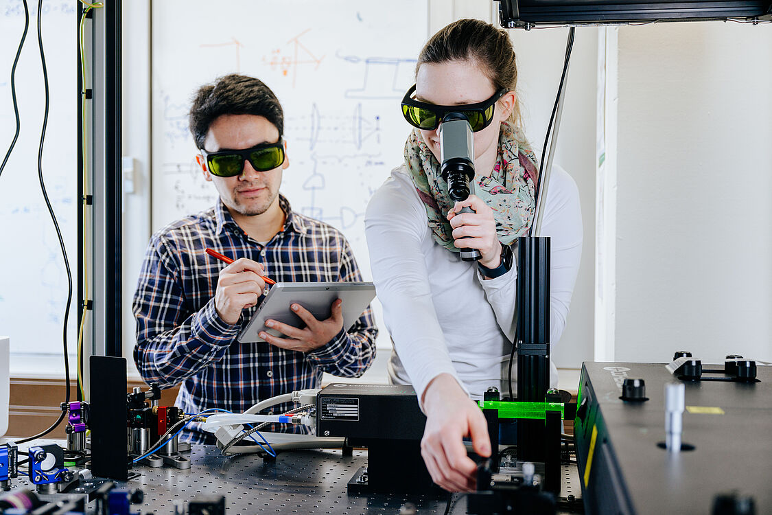 two young researchers in front of a technical device. 