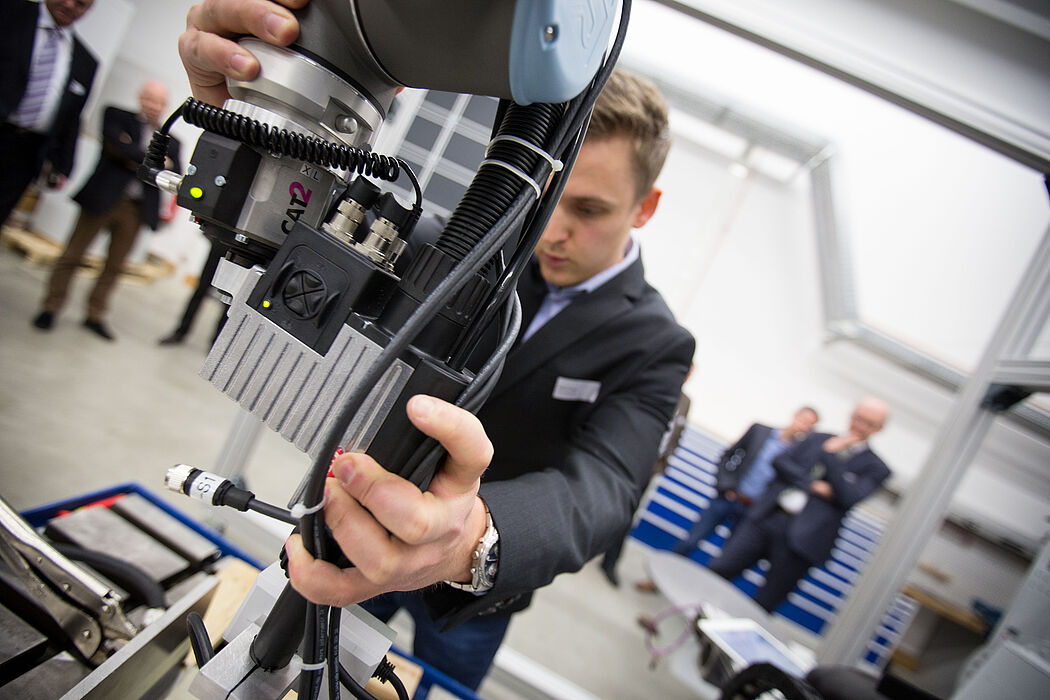 Stefan Schütz (Fraunhofer IEM) zeigt die Zusammenarbeit mit einem kollaborativen Roboter. Foto: David Gense