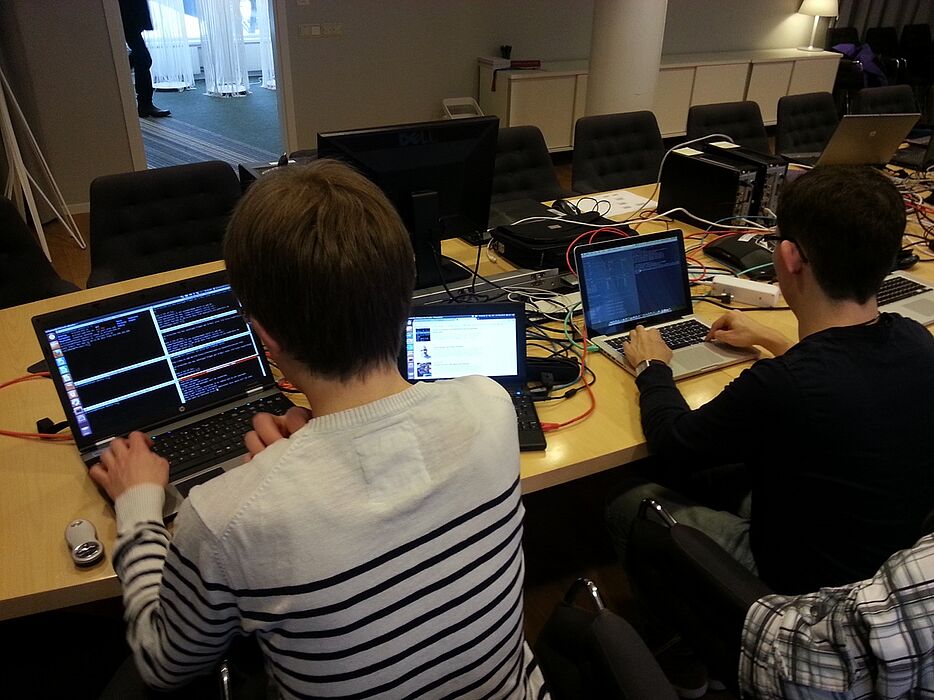 Foto (Matthias Keller): Studierende und Mitarbeiter des Projektes ComGreen testen, wie Optimierungsalgorithmen im Testbett laufen.