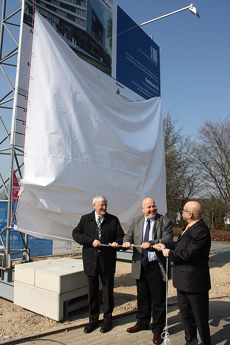 Enthüllen das Bauschild: Paderborns Bürgermeister Heinz Paus, BLB-Niederlassungsleiter Heinrich Micus und Uni-Kanzler Jürgen Plato (v. l.).