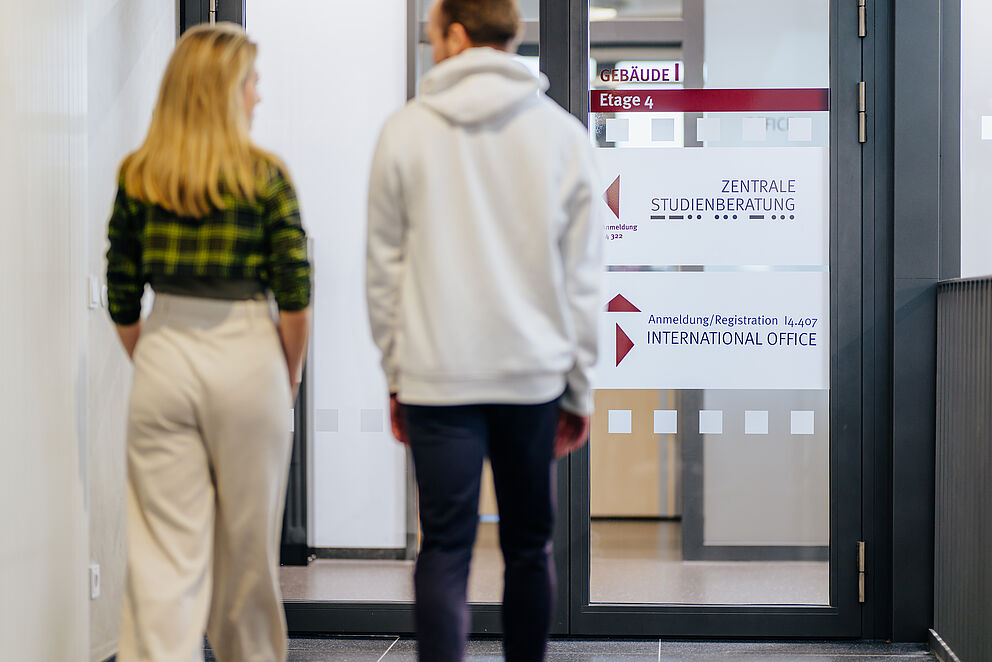 Studierende gehen durch Tür im I-Gebäude