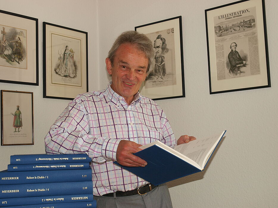Foto (Universität Paderborn, Martin Decking): Dr. Wolfgang Kühnhold freut sich über das Erscheinen der siebenbändigen Werkausgabe der Meyerbeer Oper „Robert der Teufel“.