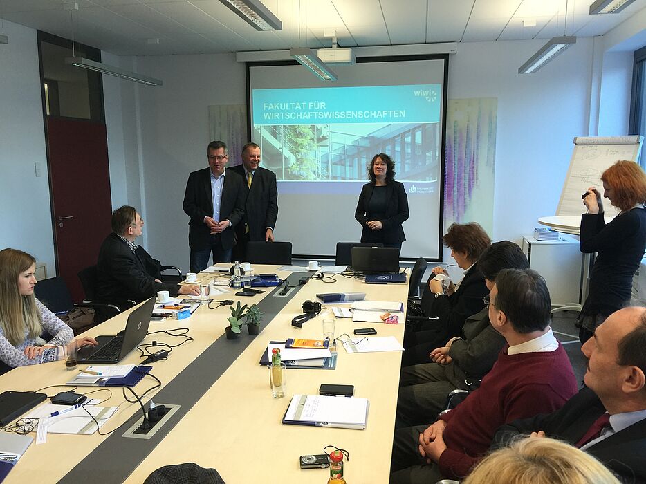 Foto: Dr. Viachaslau Nikitsin (l.), Projektkoordinator Prof. Dr. Dr. h. c. mult. Klaus Rosenthal (m.) und die Dekanin der Fakultät Wiwi, Frau Prof. Dr. Caren Sureth-Sloane (r.), begrüßen die Projektteilnehmer.