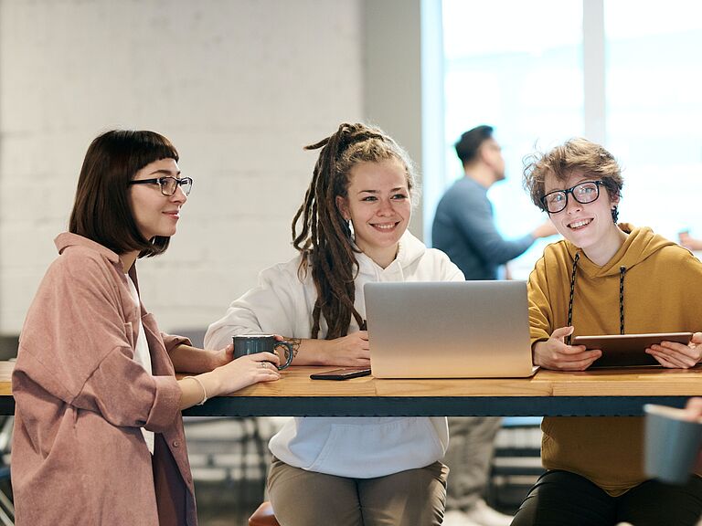 Doktorandinnen sitzen zusammen und beraten sich.