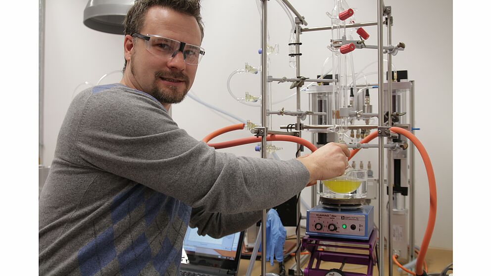 Foto (Universität Paderborn, Nina Reckendorf): Prof. Dr. Matthias Bauer vor der Apparatur zur Spaltung von Wasser