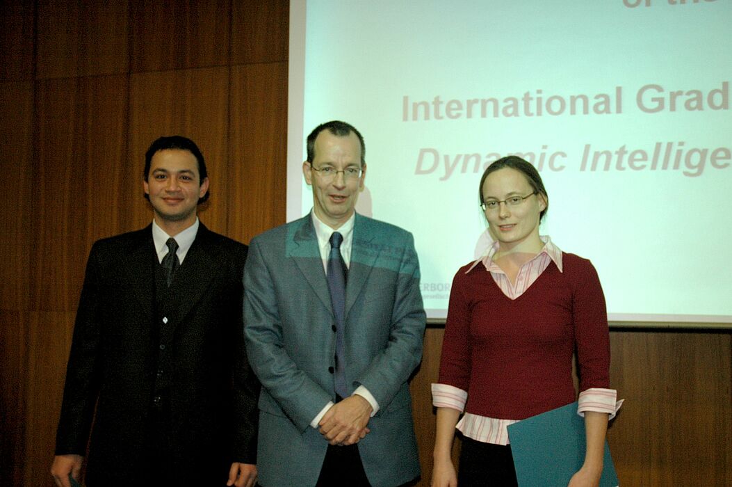 Foto: Prof. Dr. Erik Woldt (Hellla KG aA Hueck & Co.) und die neuen "Hella Fellows" Sabine Raphael und "Hatem Shaaded" von der International Graduate School "Dynamic Intelligent Systems" der Universität Paderborn