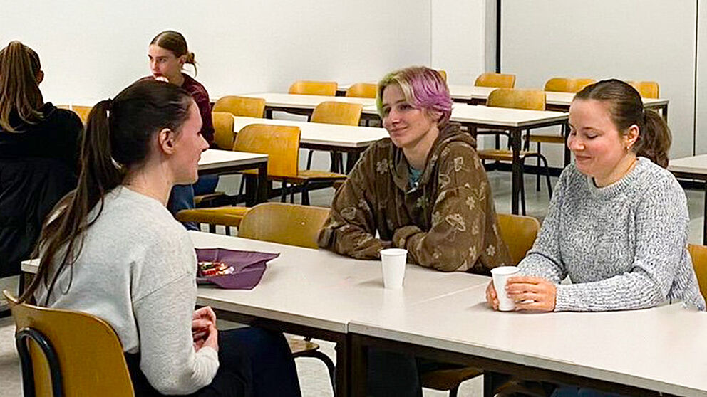 Schülerinnen sprechen am Tisch mit Mentorinnen