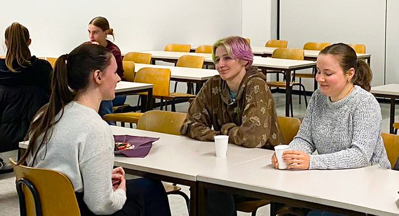 Schülerinnen sprechen am Tisch mit Mentorinnen