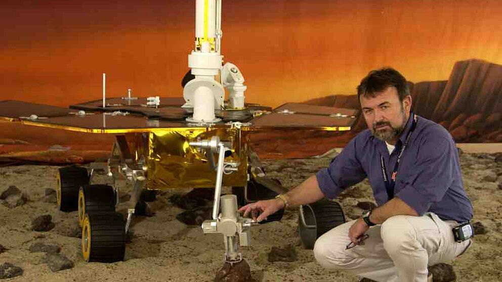 Foto: Ein Rover-Fahrzeug in einer dem Mars nachgestellten Landschaft mit Dr. Göstar Klingelhöfer von der Universität Mainz, der an der Uni Paderborn über "Wasser auf dem Mars?" referieren wird