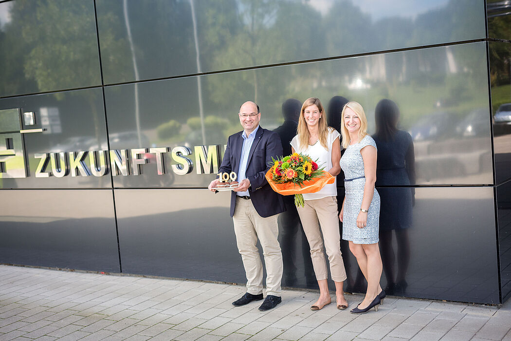 Foto (David Gense): Dreistellig! Prof. Ansgar Trächtler (Leiter Fraunhofer IEM) und Sabrina Donnerstag (Gruppenleiterin Fraunhofer IEM, rechts) begrüßen ihre 100. Mitarbeiterin Hanna Busemann (Mitte).