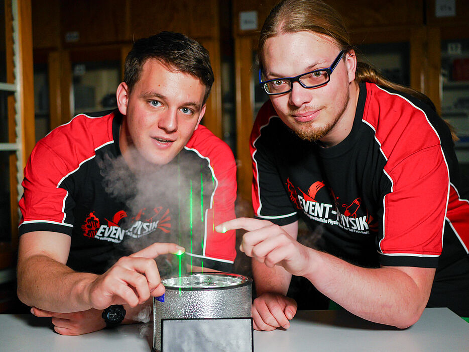 Foto (Universität Paderborn, Johannes Pauly):  Die Event-Physiker Carsten Müller (li.) und Tim Eichelberger testen Laser für den Aufbau einer großen Laserharfe. 