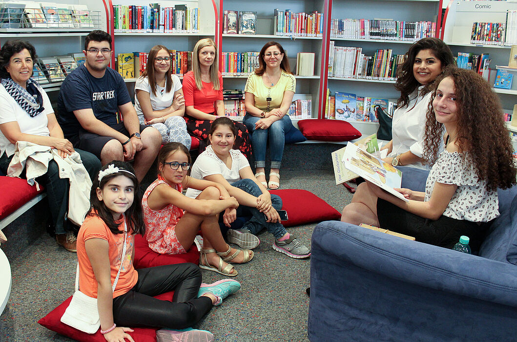 Foto (Universität Paderborn, Ricarda Michels): Hala Alkhatib und Meryem Düzel (Erste und Zweite v. r.) lasen Kindern und Eltern in der Paderborner Kinderbibliothek auf Arabisch, Deutsch und Türkisch vor.