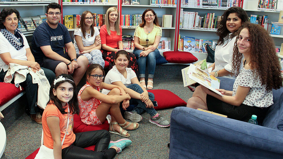 Foto (Universität Paderborn, Ricarda Michels): Hala Alkhatib und Meryem Düzel (Erste und Zweite v. r.) lasen Kindern und Eltern in der Paderborner Kinderbibliothek auf Arabisch, Deutsch und Türkisch vor.