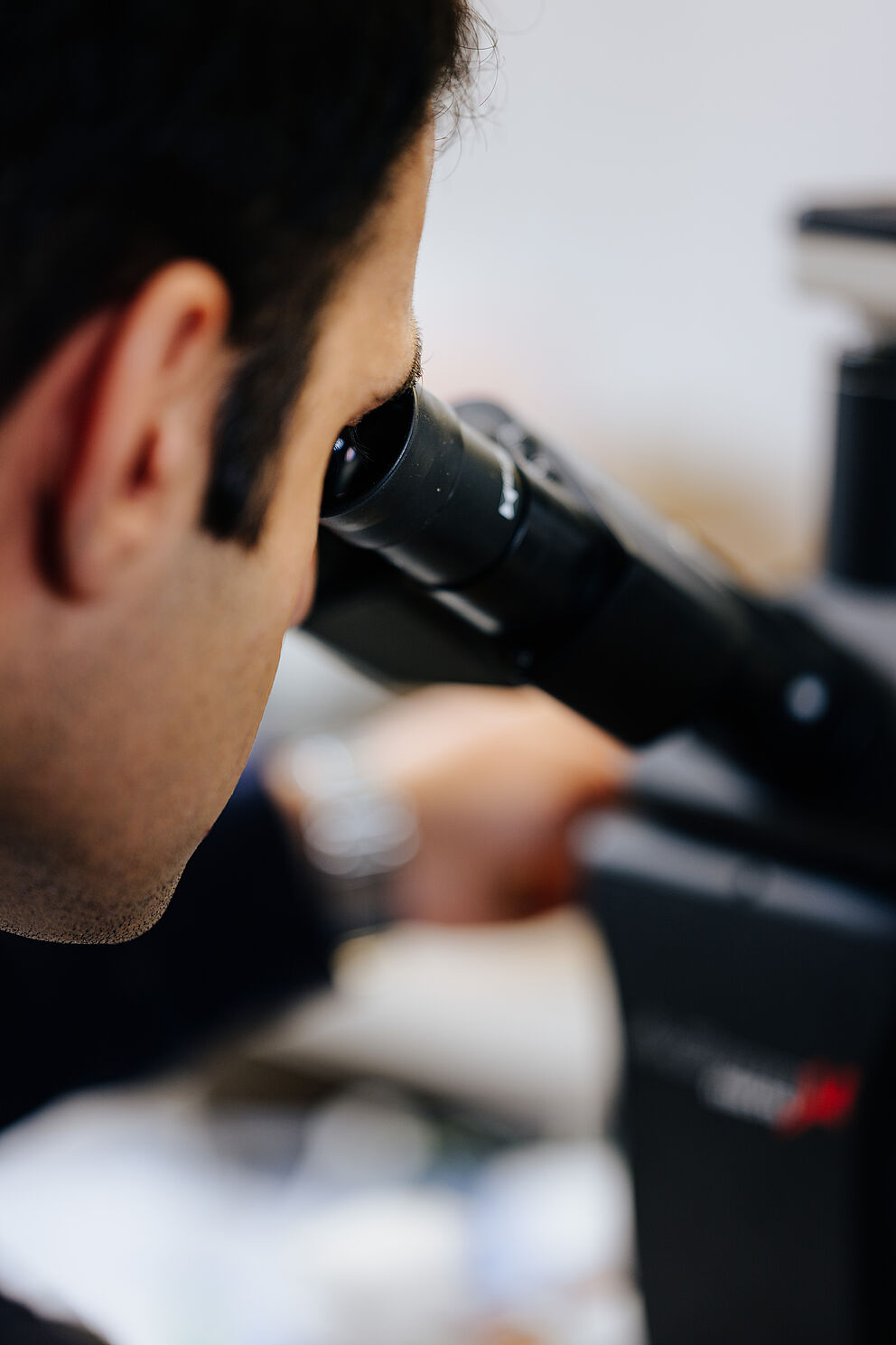 Forscher schaut durch Mikroskop