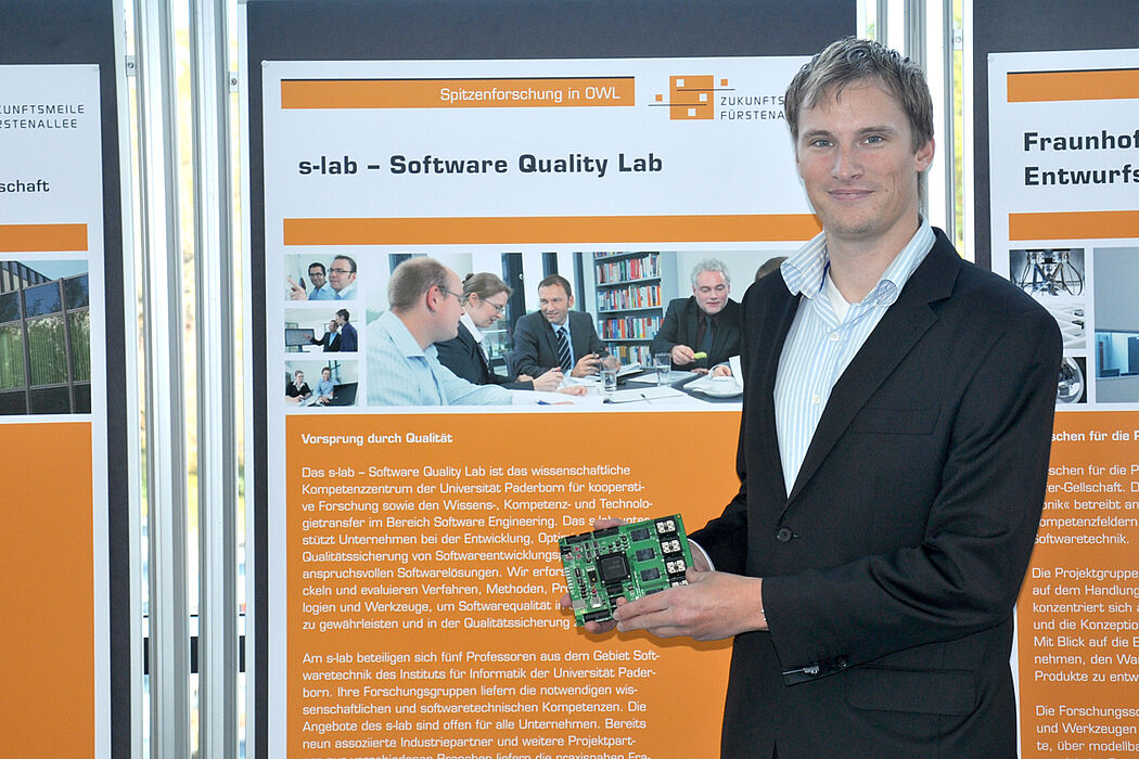 Foto (Jannic Hüsemann): Dipl.-Inform. Daniel Baldin mit einem Evaluationsboard – einem vergrößerten Modell einer Smart Card.